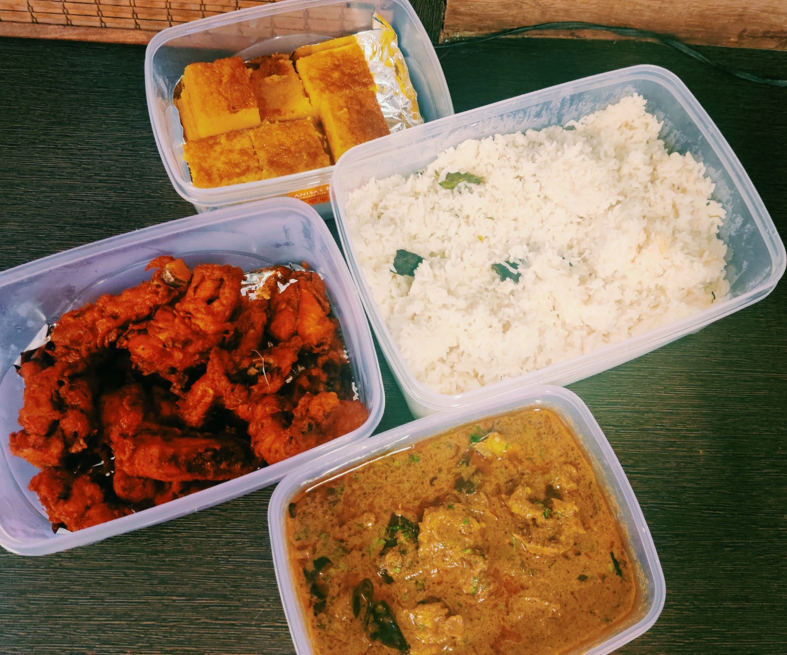 Packed meal boxes with fried chicken, curry, rice and dessert