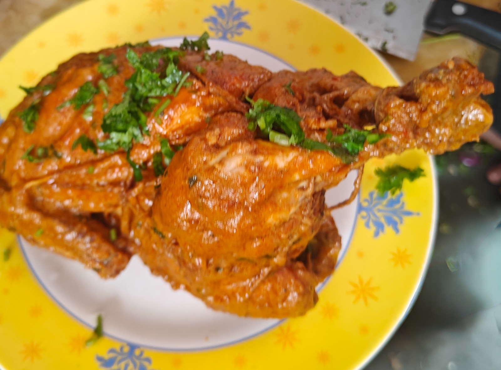 Whole chicken masala plated and garnished with coriander