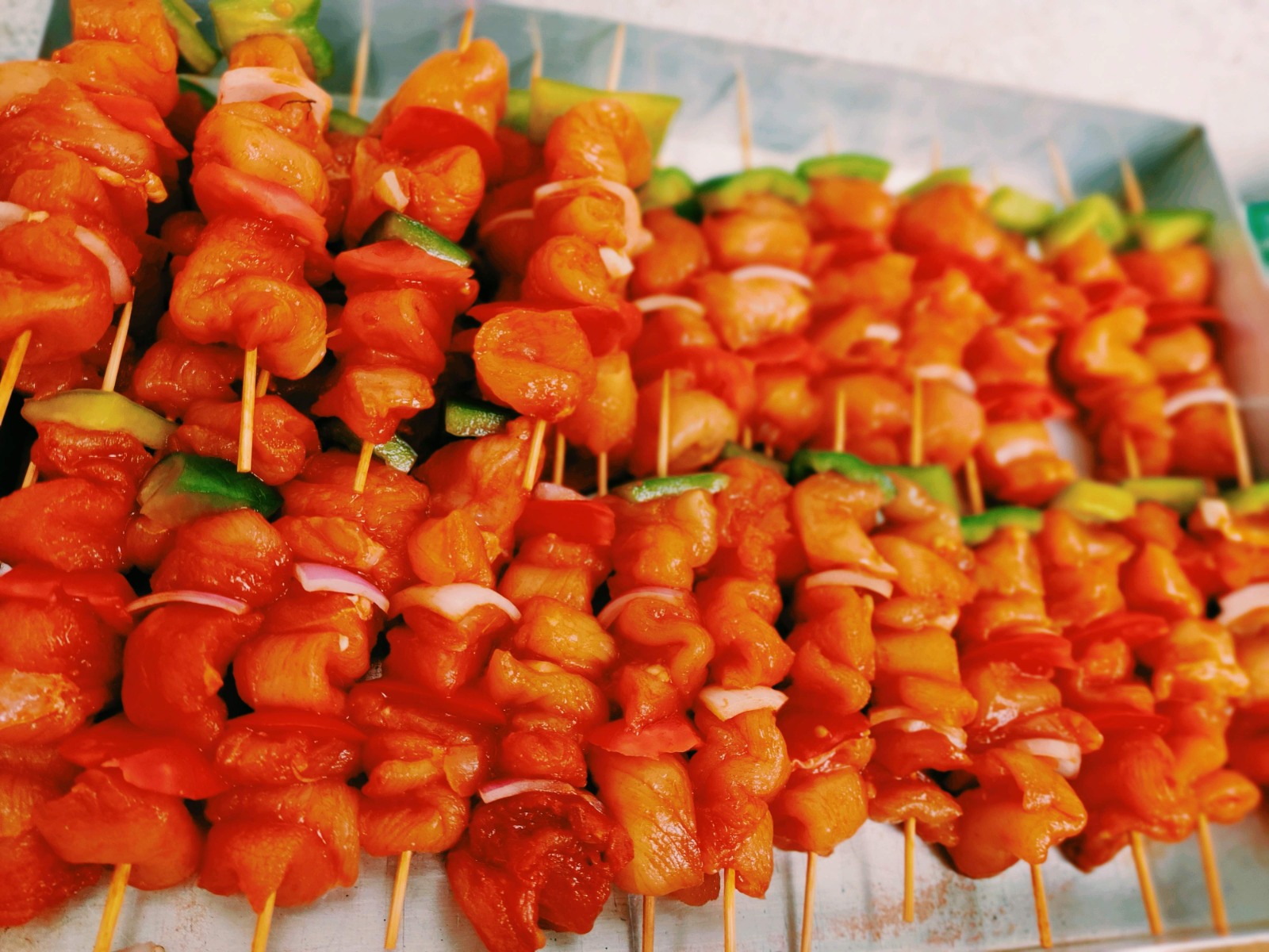Chicken tikka skewers with peppers ready for the grill
