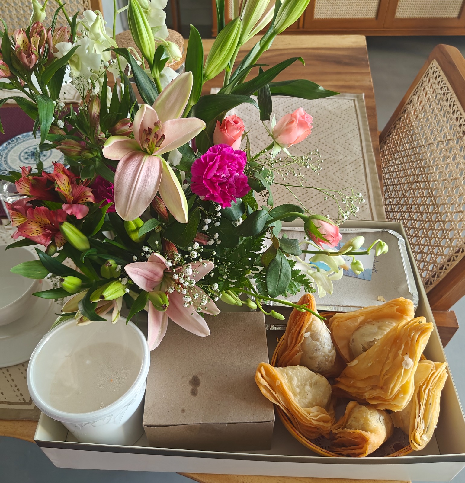 Gift hamper of warki samosas with a floral bouquet