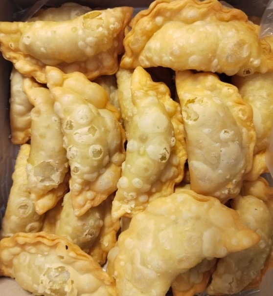 Freshly fried crescent samosas in a box