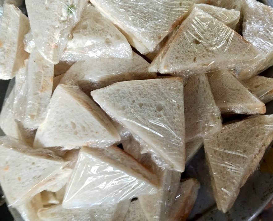 Tray of triangle party sandwiches wrapped for an event