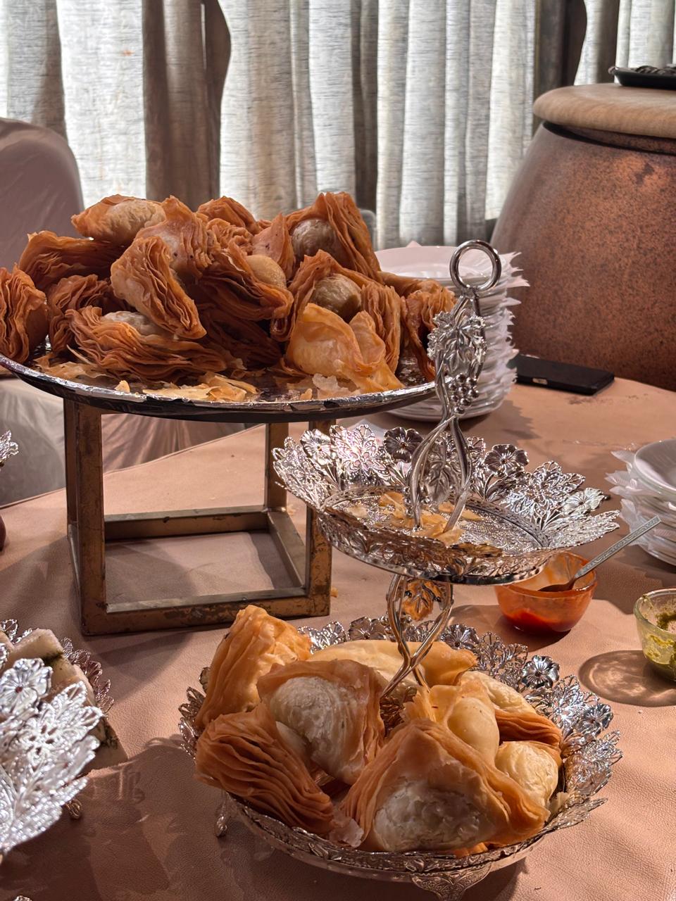 Layered warki samosas served on a silver tiered stand