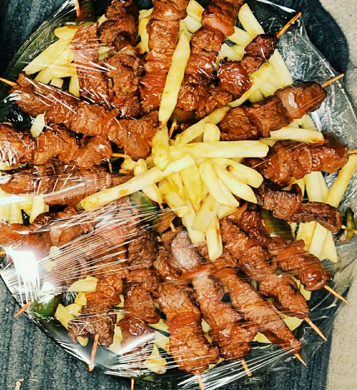 Platter of beef skewers with golden fries