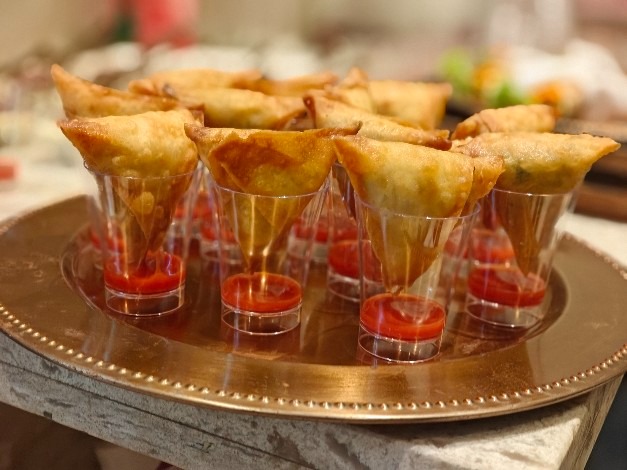 Crisp cocktail samosas served in shot glasses with red chutney